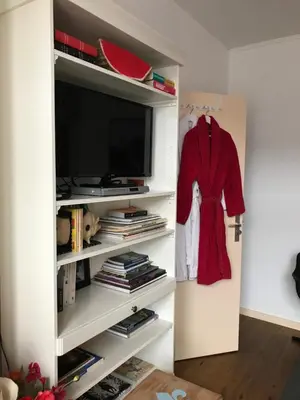 a red shirt is hanging in a white book shelf at Six in Amsterdam