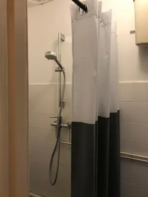 a shower with a black and white shower curtain at Six in Amsterdam