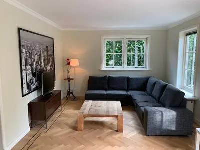 a living room with a blue couch and a coffee table at Vakantiehuis Villa Zeewolde in Zeewolde