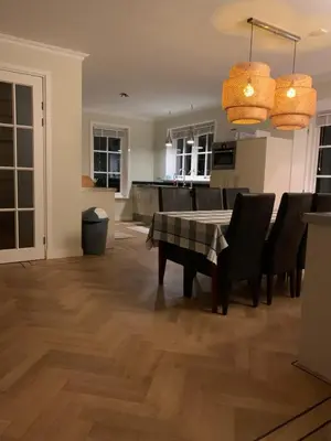 a dining room and kitchen with a table and chairs at Vakantiehuis Villa Zeewolde in Zeewolde