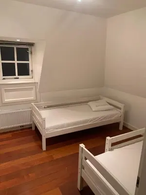 a small room with two beds and a window at Vakantiehuis Villa Zeewolde in Zeewolde