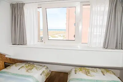 a room with a window and a bed with a pillow at Emma's beach house in Katwijk aan Zee