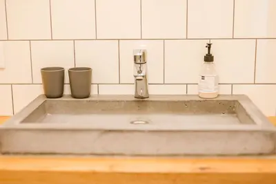 a sink with two cups and a soap bottle at Emma's beach house in Katwijk aan Zee