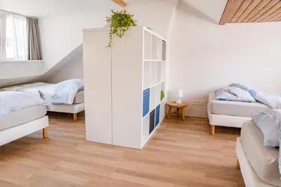 a room with two beds and a white cabinet at Emma's beach house in Katwijk aan Zee