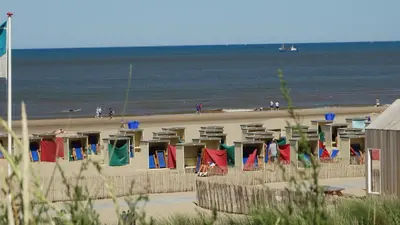 a beach with chairs and people on the beach at Emma's beach house in Katwijk aan Zee