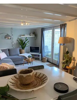 a living room with a couch and a table at Dromen aan het strand in Egmond aan Zee