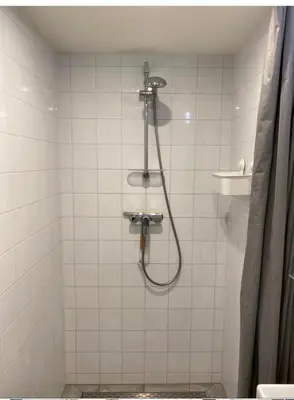 a shower with a hose in a bathroom at Dromen aan het strand in Egmond aan Zee