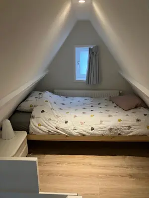 a bedroom with a bed in the attic at Dromen aan het strand in Egmond aan Zee