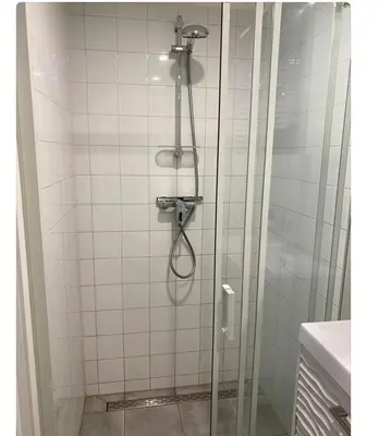 a shower in a bathroom with a glass door at Dromen aan het strand in Egmond aan Zee