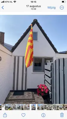 a house with a flag hanging off the side of it at Dromen aan het strand in Egmond aan Zee