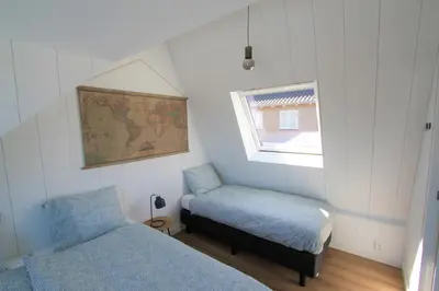 a small bedroom with a bed and a window at Beaufort in Egmond aan Zee
