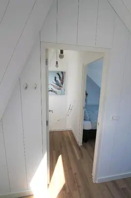 a room with white cabinets and a bedroom at Beaufort in Egmond aan Zee