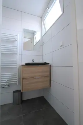 a bathroom with a sink and a mirror at Beaufort in Egmond aan Zee