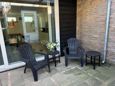 two chairs and a table on a patio at Beaufort in Egmond aan Zee