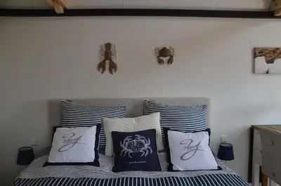 a bedroom with a bed with blue and white pillows at Froukje's B&B in Woerdense Verlaat