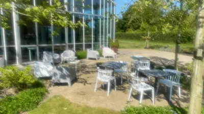a group of tables and chairs in front of a building at Onze Kas in Lelystad