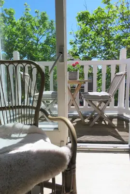 a porch with two chairs and a table on a deck at Sea shell with balcony close to the beach, city centre and dunes in Zandvoort