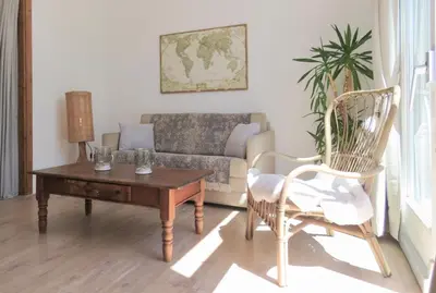a living room with a couch and a table and a chair at Sea shell with balcony close to the beach, city centre and dunes in Zandvoort