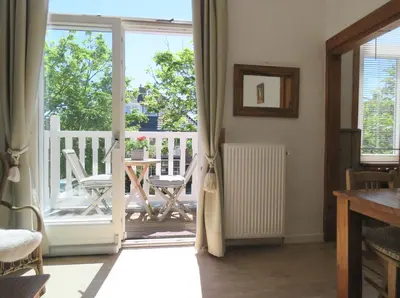 an open door to a balcony with a table and chairs at Sea shell with balcony close to the beach, city centre and dunes in Zandvoort