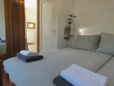 a bedroom with a bed with two towels on it at Sea shell with balcony close to the beach, city centre and dunes in Zandvoort
