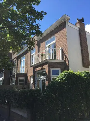 a brick house with a balcony on the side of it at Sea shell with balcony close to the beach, city centre and dunes in Zandvoort