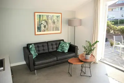 a living room with a black couch and a table at Huis Zeeduin Amsterdam Beach in Zandvoort