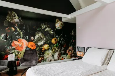 a bedroom with a painting of flowers on the wall at Boutique B&B Oud Aa in Breukelen