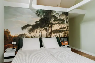 a bedroom with a bed with a painting on the wall at Boutique B&B Oud Aa in Breukelen