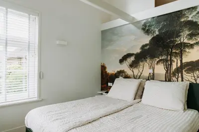 a bedroom with a bed with a painting on the wall at Boutique B&B Oud Aa in Breukelen