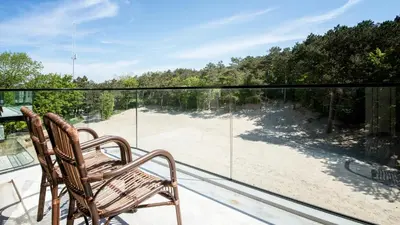 a balcony with a bench and a view of a beach at De Egmonden in Egmond aan Zee