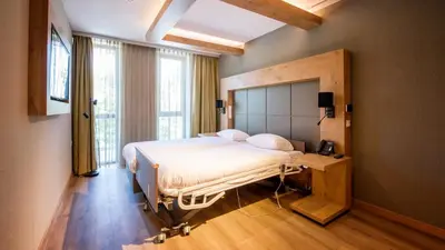 a bedroom with a bed and a large window at De Egmonden in Egmond aan Zee