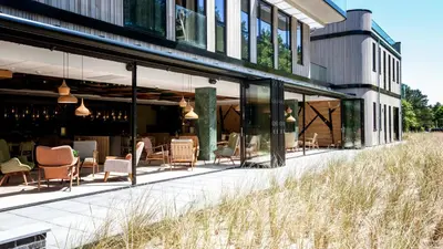 a patio of a building with chairs and tables at De Egmonden in Egmond aan Zee