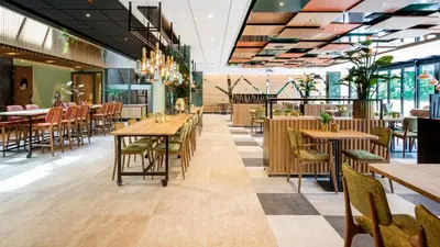 a restaurant with wooden tables and chairs at De Egmonden in Egmond aan Zee