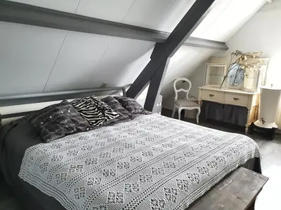 a bedroom with a white bed and a dresser at Apartment Het Friesche Paard in Purmer
