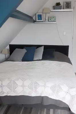 a bedroom with a white bed with blue pillows at Apartment Het Friesche Paard in Purmer