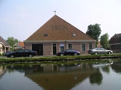 three cars parked in front of a house next to a body of water at 
