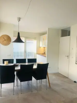 a dining room with a table and chairs at Strand Villa Stern Noordwijk in Noordwijk