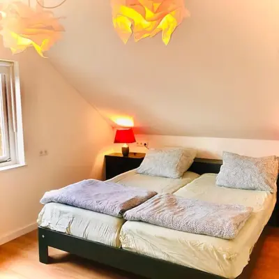 a bedroom with two beds and a ceiling at Strand Villa Stern Noordwijk in Noordwijk