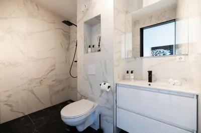 a white bathroom with a toilet and a sink at Boutique Hotel 43 Amsterdam - Zaandam in Koog aan de Zaan
