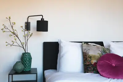 a bedroom with a bed with a purple pillow and a side table at Boutique Hotel 43 Amsterdam - Zaandam in Koog aan de Zaan