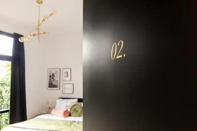 a bedroom with a bed and a wall with a clock on it at Boutique Hotel 43 Amsterdam - Zaandam in Koog aan de Zaan