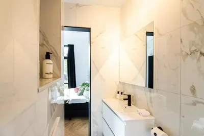 a white bathroom with a sink and a mirror at Boutique Hotel 43 Amsterdam - Zaandam in Koog aan de Zaan