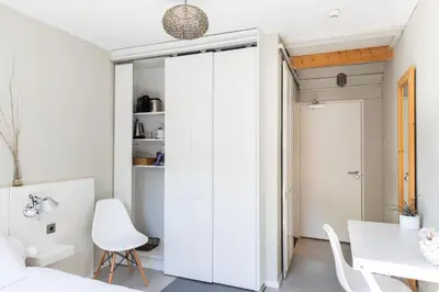 a bedroom with a white closet and a table and chairs at Hotelroom Villa 1913 in Bergen