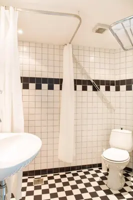 a bathroom with a white toilet and a sink at Hotelroom Villa 1913 in Bergen