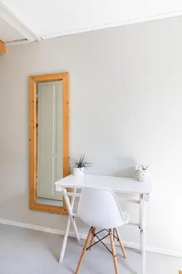 a white table and a chair in front of a mirror at Hotelroom Villa 1913 in Bergen