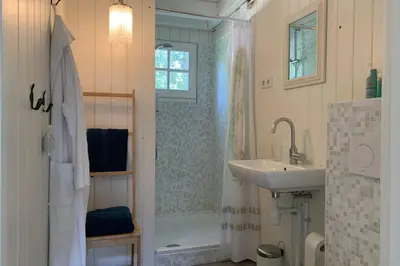 a bathroom with a sink and a shower and a tub at Bergen, Huisje dat ademt zee en vakantie... in Bergen