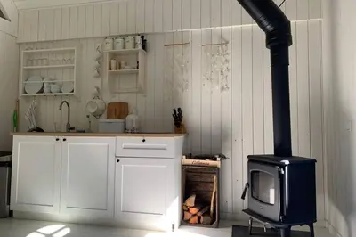 a kitchen with a stove and a microwave at Bergen, Huisje dat ademt zee en vakantie... in Bergen