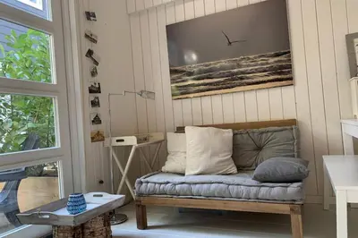 a living room with a couch and a table at Bergen, Huisje dat ademt zee en vakantie... in Bergen