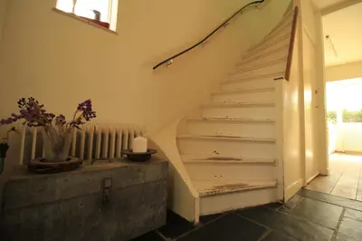 a staircase in a house with a vase of flowers at House Akerdijk 5 persons 3 bedrooms in Badhoevedorp