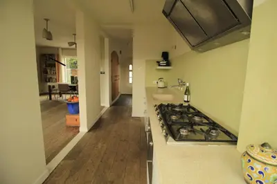 a kitchen with a stove top oven next to a hallway at House Akerdijk 5 persons 3 bedrooms in Badhoevedorp